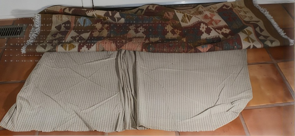 Rug pad placed beneath a patterned area rug, showing the pad’s fit and potential for shifting or bunching.