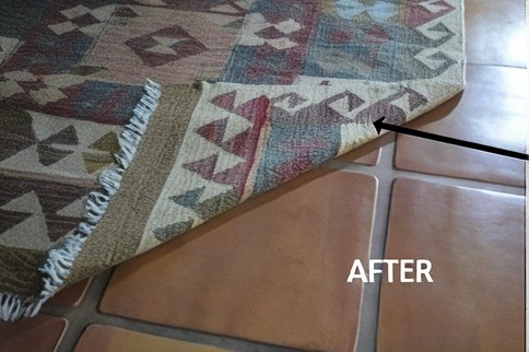 Treated rug backing with a visible coating applied to help keep the area rug from sliding.
